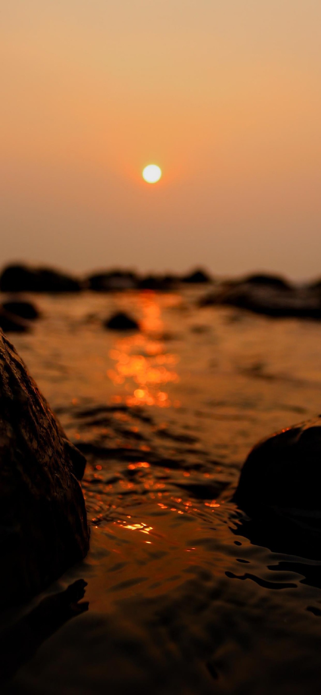 beach sunset rocks pebbles water